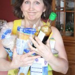 Jennifer Cote displays common GMO groceries: Pasta, Sugar, Rice, Tomatoes, Soy